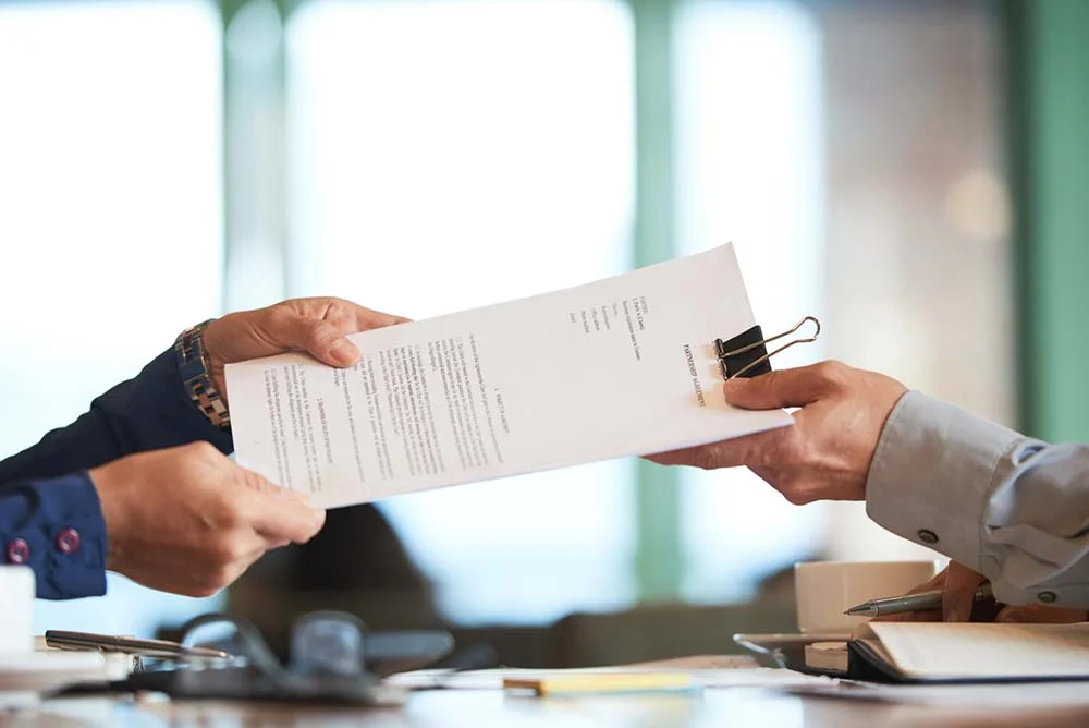 closeup hands passing contract unrecognizable businessman 1 ประกันสังคม